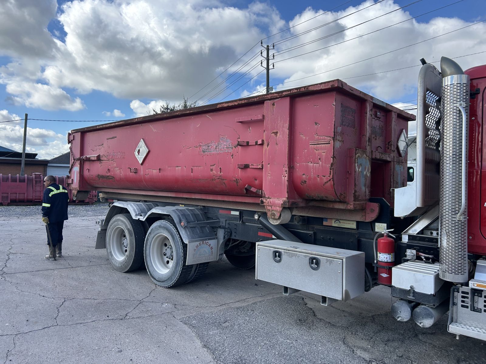 Used open top roll-off loaded on a truck, side view