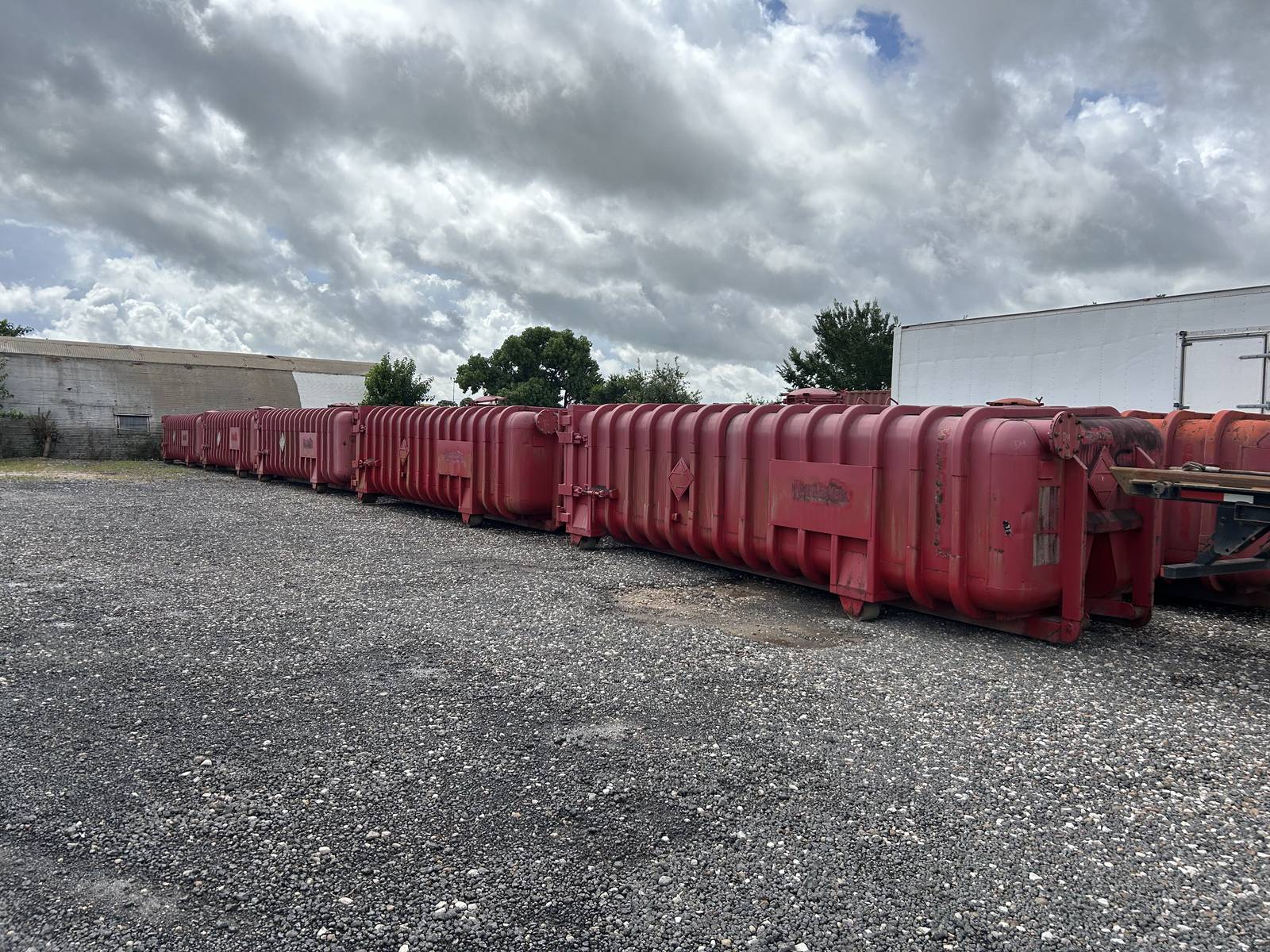 Long row of used Roll-Off Vacuum Tanks in our Houston yard