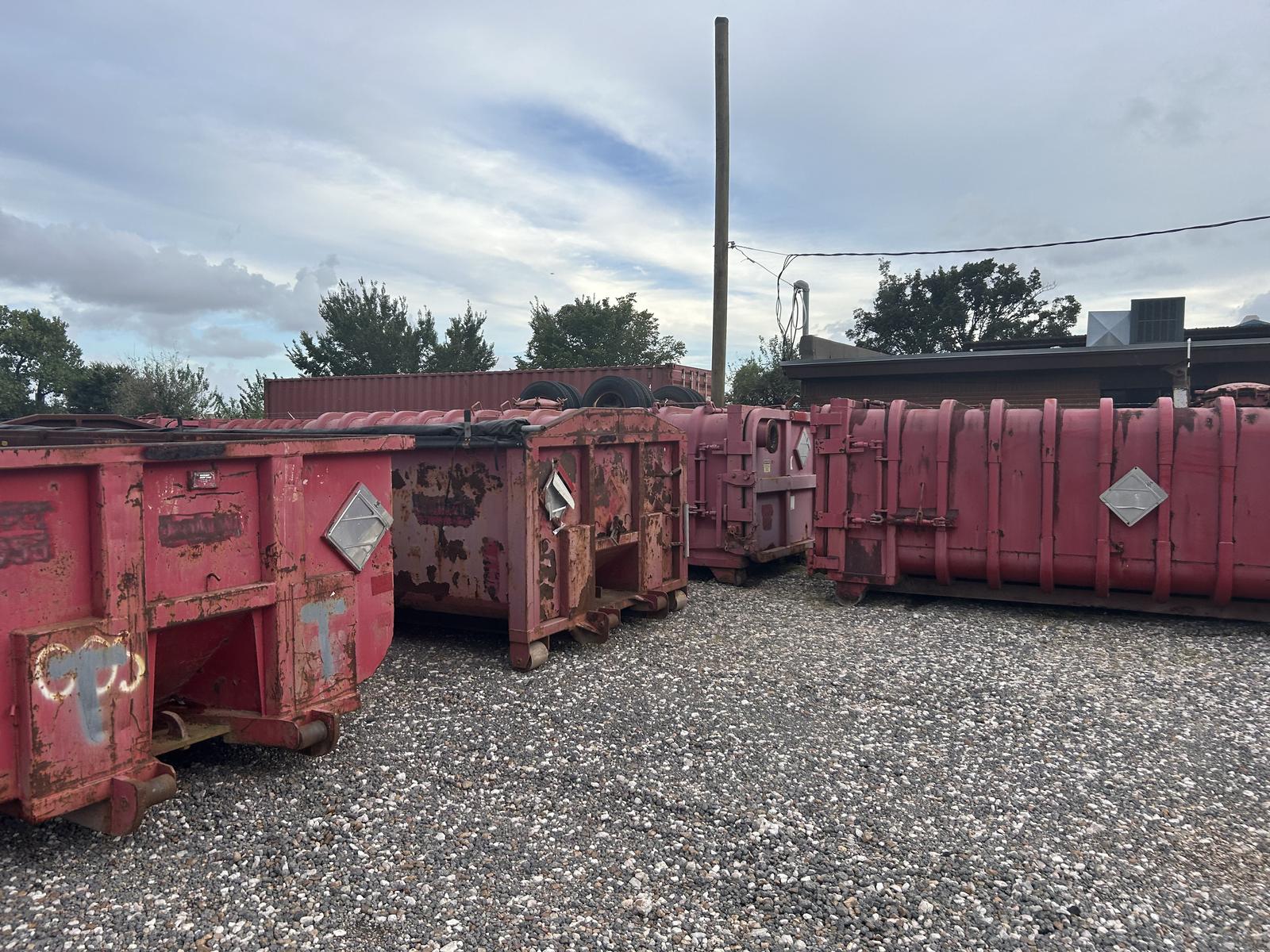 Used roll-off containers with lids in the yard